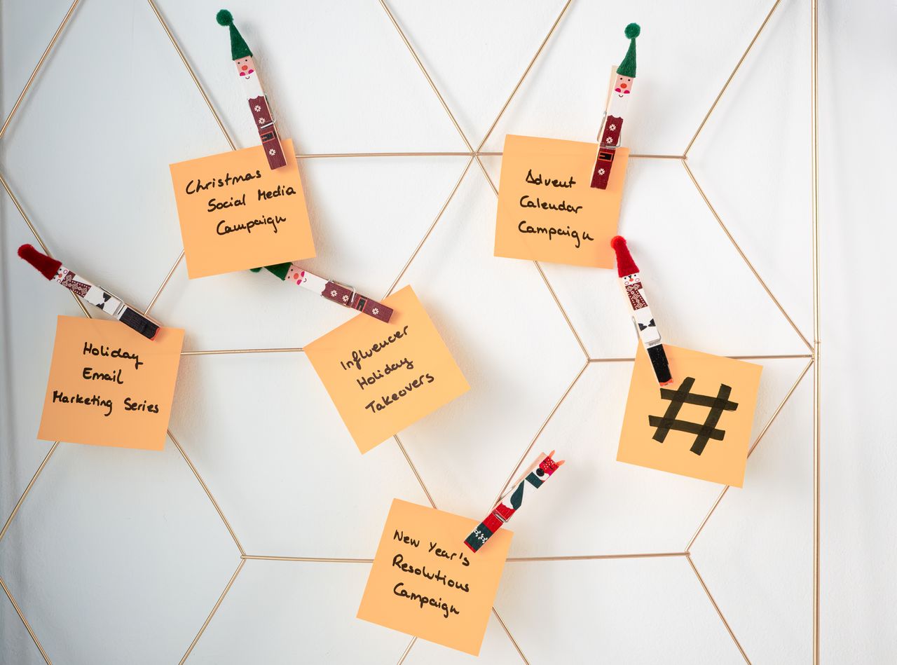 Sticky notes with holiday marketing ideas clipped to a wall grid.
